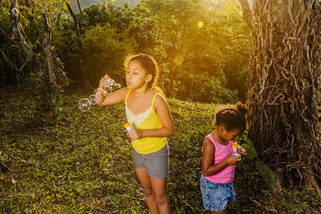 Foto gratuita hermanas jóvenes haciendo burbujas de jabón