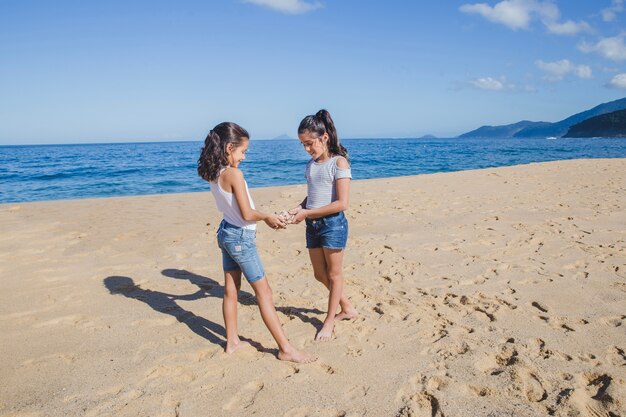 Hermanas jugando con una caracola