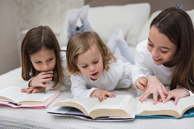 Foto gratuita hermanas leyendo libro juntas