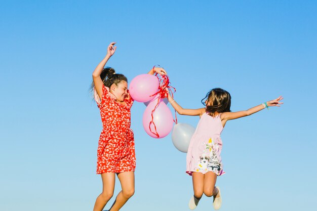 Hermanas saltando con globos