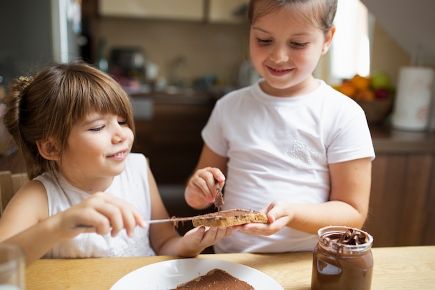 Hermanas sonrientes compartiendo el desayuno juntos