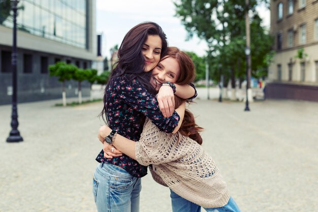 Hermanas sonrientes despreocupadas abrazándose y divirtiéndose juntas