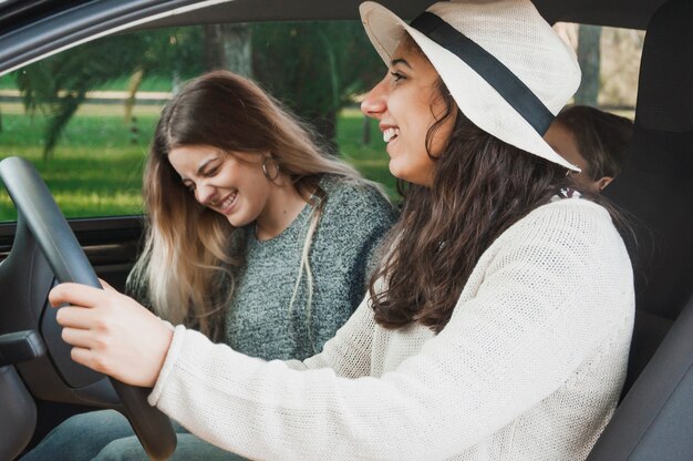 Hermanas sonrientes sentado dentro del coche