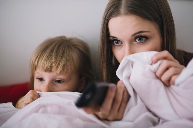 Hermanas viendo una película de miedo en la televisión