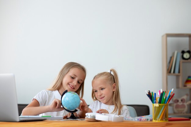 Hermanitas haciendo escuela en línea juntas en casa