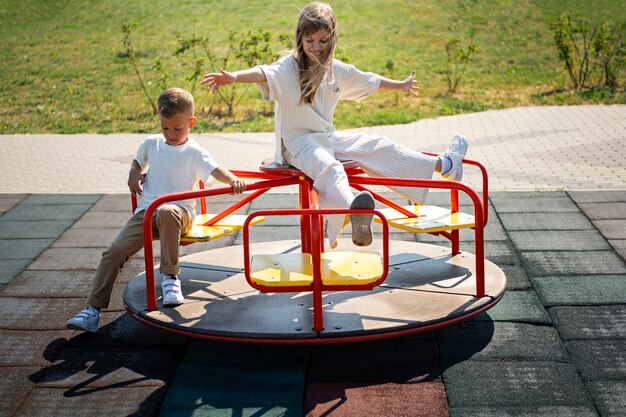 Hermano y hermana divirtiéndose en el patio de recreo al aire libre