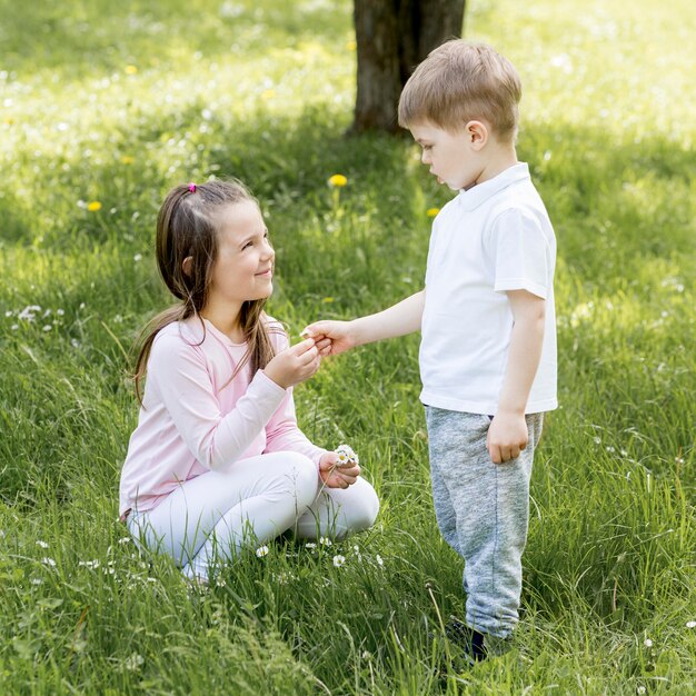 Hermano y hermana jugando en la hierba