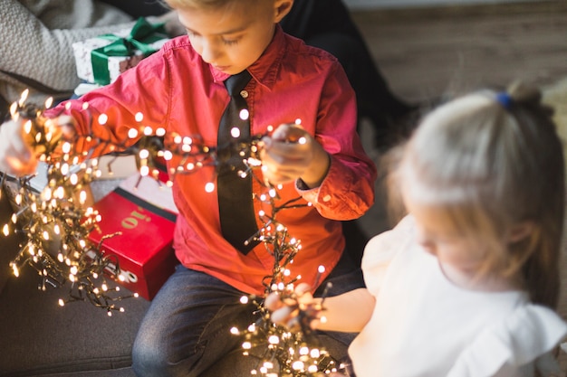 Hermano y hermana con luces de navidad