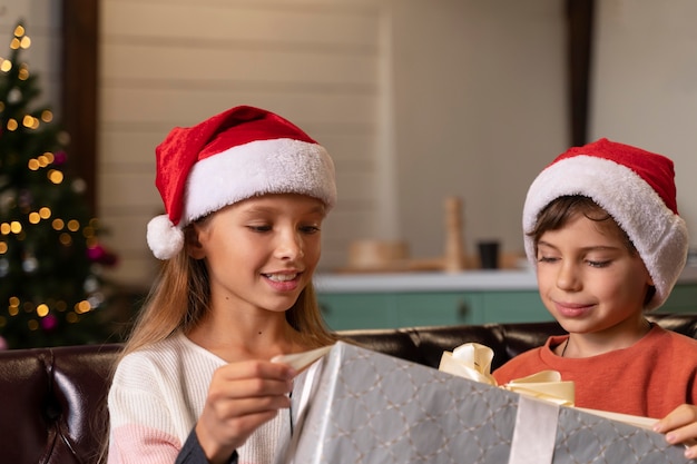 Hermanos abriendo juntos un regalo de navidad