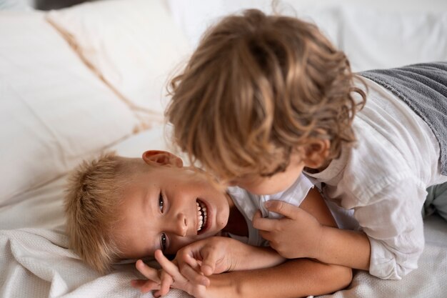 Hermanos de alto ángulo jugando en la cama