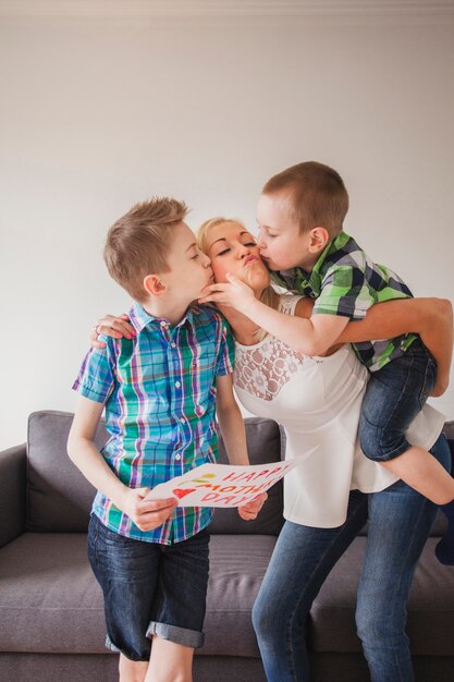 Hermanos besando a su madre en el día de la madre
