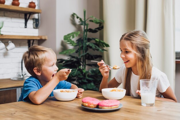 Hermanos comiendo juntos en la cocina