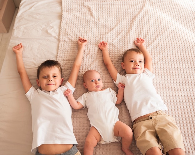 Hermanos felices con bebé recién nacido