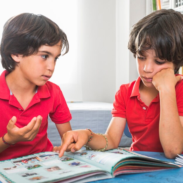 Hermanos hablando sentado con libro