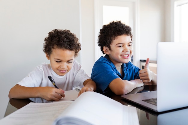 Hermanos haciendo los deberes en casa durante la nueva normalidad