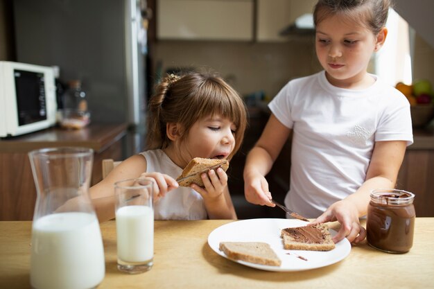 Hermanos jóvenes desayunando en casa