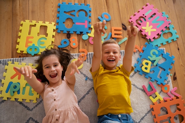 Foto gratuita hermanos jugando con juguetes de acertijo