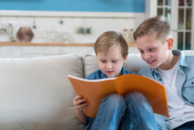 Hermanos leyendo un libro juntos