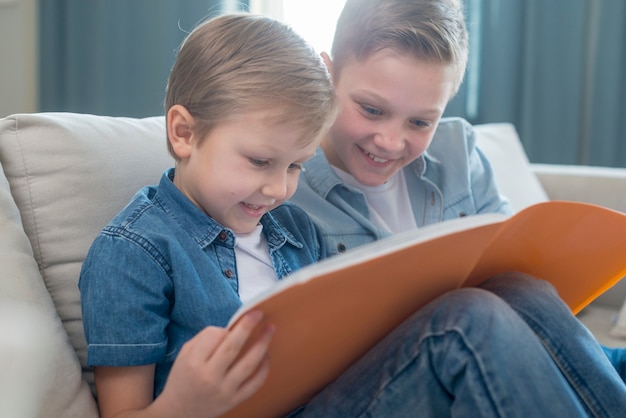 Hermanos leyendo un libro juntos