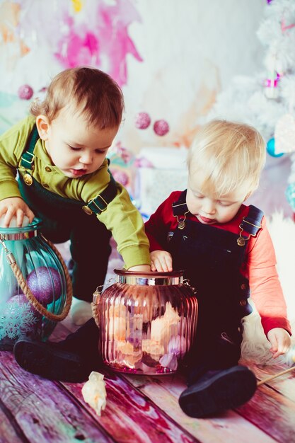 Los hermanos pequeños jugando con jarrones con velas