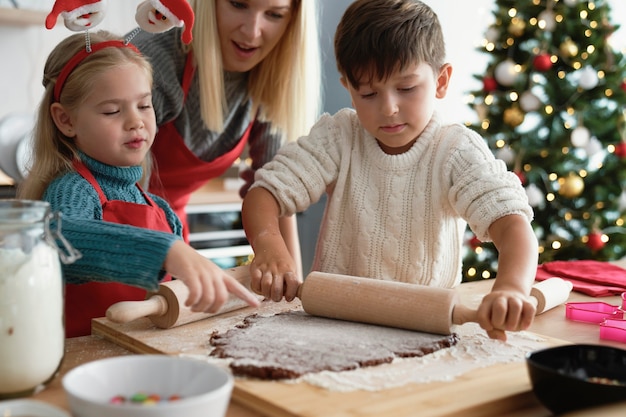 Hermanos rodando una masa de pan de jengibre