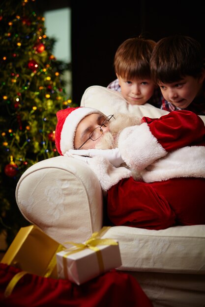 Foto gratuita hermanos con santa dormido en el sofá