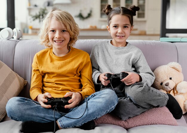 Hermanos en el sofá con joysticks jugando