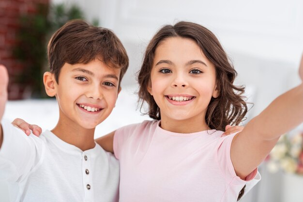 Hermanos sonrientes de alto ángulo abrazando