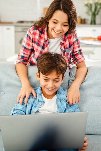 Hermanos sonrientes de alto ángulo con laptop