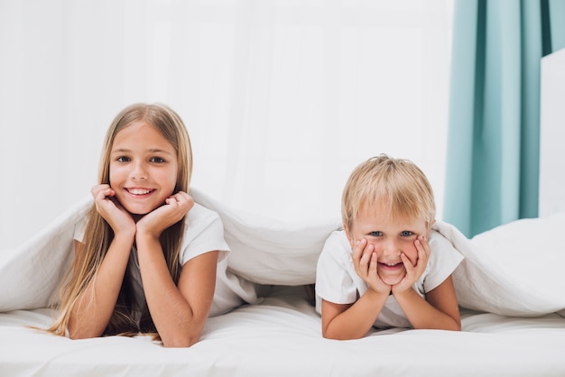 Foto gratuita hermanos sonrientes mirando a la cámara