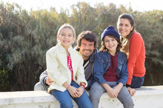 Hermanos sonrientes sentados con sus padres