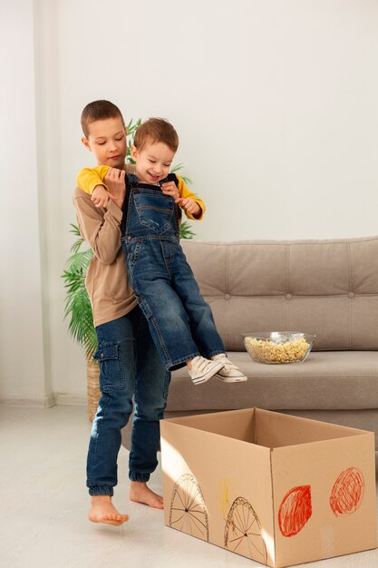 Hermanos de tiro completo jugando con caja.