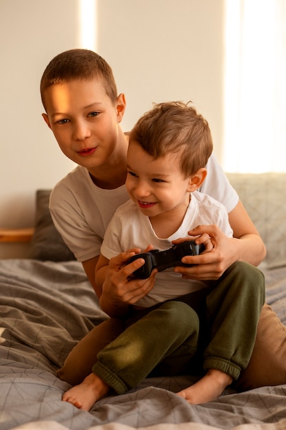 Foto gratuita hermanos de tiro completo jugando videojuegos.