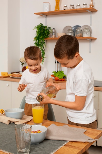 Foto gratuita hermanos de tiro medio con comida en casa.