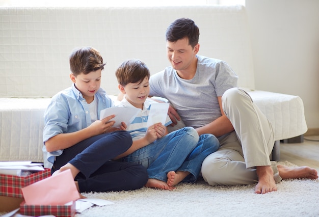 Hermanos viendo fotos con su padre