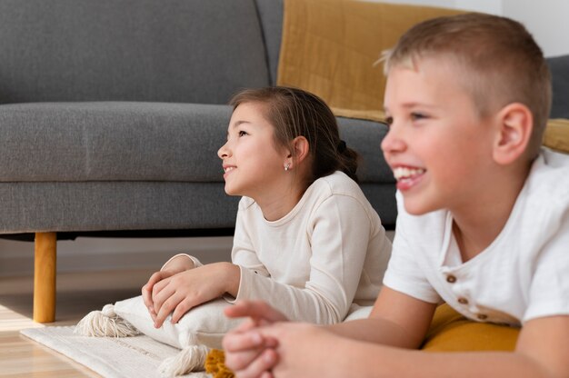 Foto gratuita hermanos viendo la televisión juntos