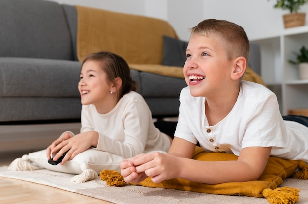 Foto gratuita hermanos viendo la televisión juntos