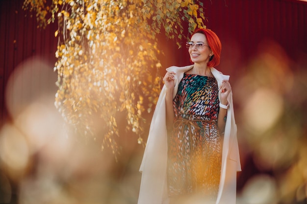 Hermosa anciana en vestido colorido fuera de la calle de otoño