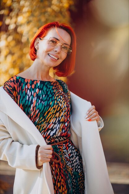 Hermosa anciana en vestido colorido fuera de la calle de otoño