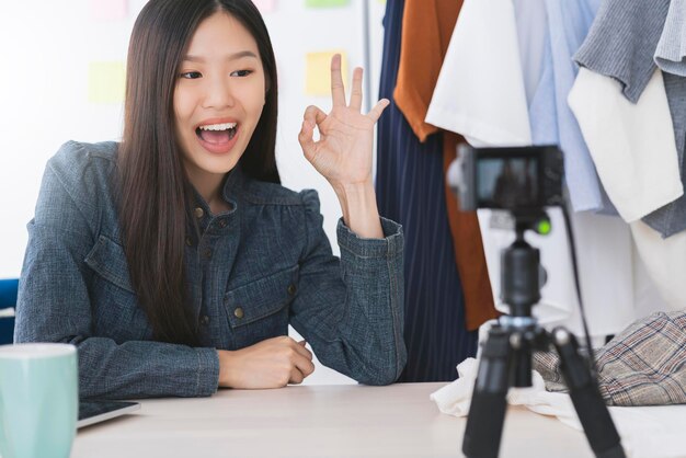 Hermosa asiática vloger o bloguera presente vestido de tela concepto de ideas en línea de la tienda de negocios en línea