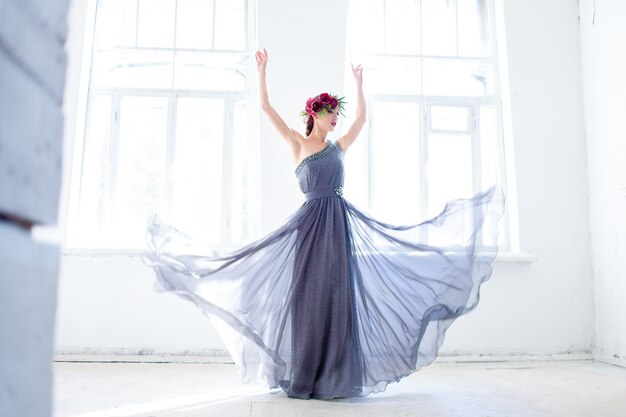 hermosa bailarina bailando en vestido largo gris