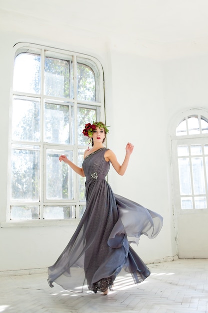 hermosa bailarina bailando en vestido largo gris