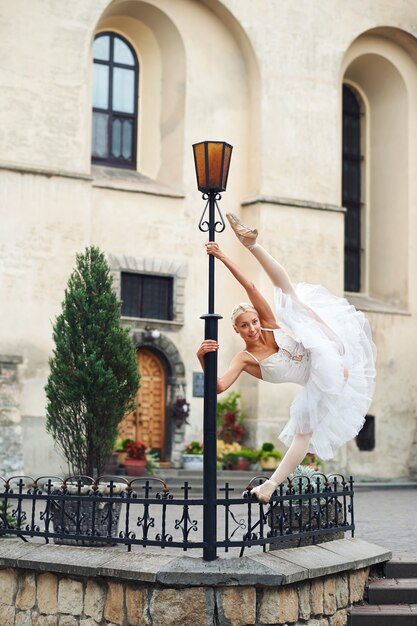 Hermosa bailarina graciosa bailando en las calles de un viejo ci