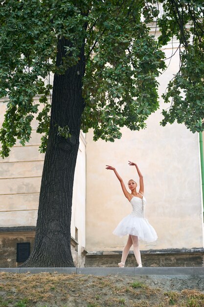 Hermosa bailarina graciosa bailando en las calles de un viejo ci