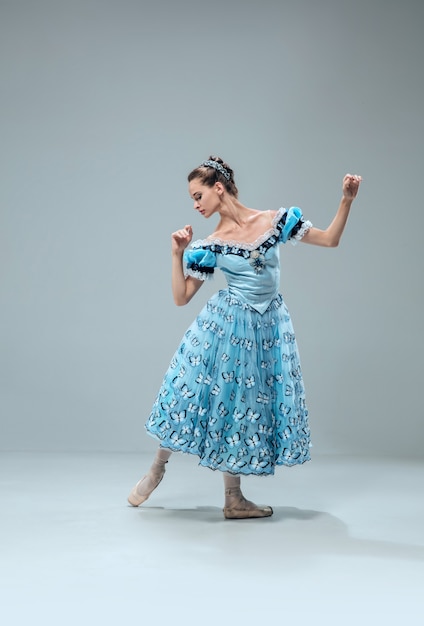 Hermosa bailarina de salón de baile contemporánea aislada en la pared gris del estudio