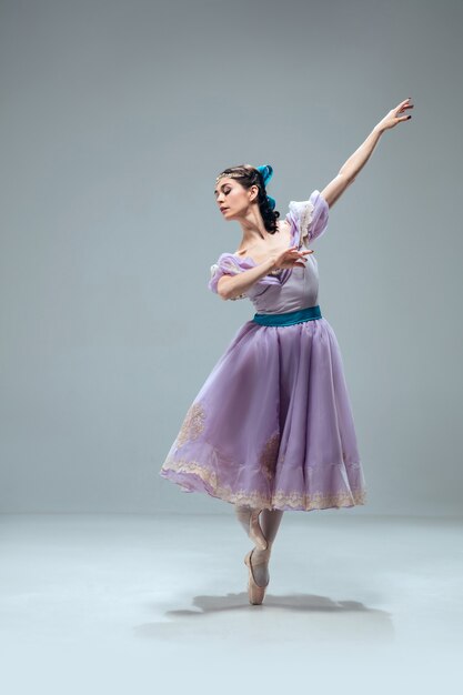 Hermosa bailarina de salón de baile contemporánea aislada sobre fondo gris.