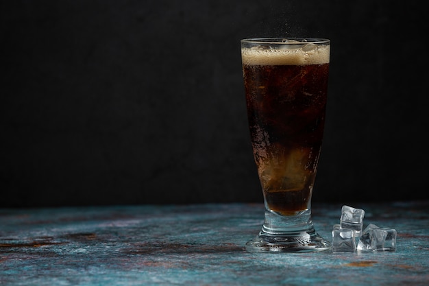 Hermosa bebida fría de cola con cubitos de hielo