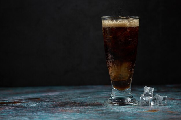 Hermosa bebida fría de cola con cubitos de hielo