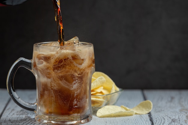 Hermosa bebida fría de cola con cubitos de hielo