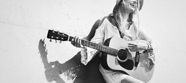 Hermosa cantautora tocando una guitarra